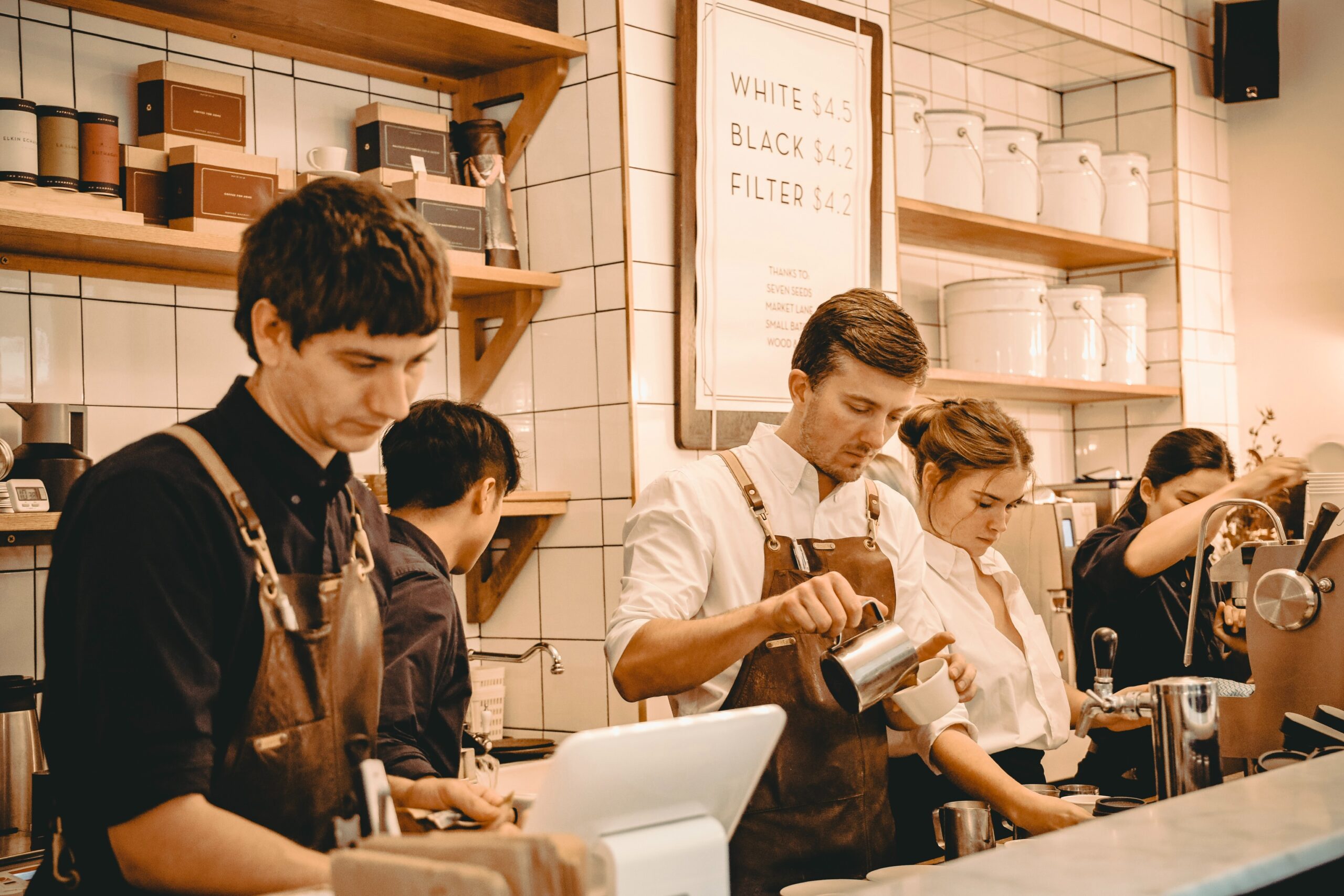 Five baristas working behind the counter.