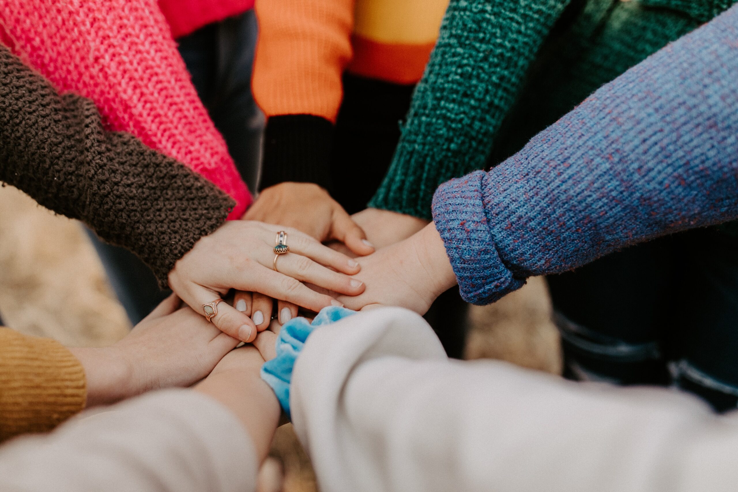 A group of people with their hands on top of one another.