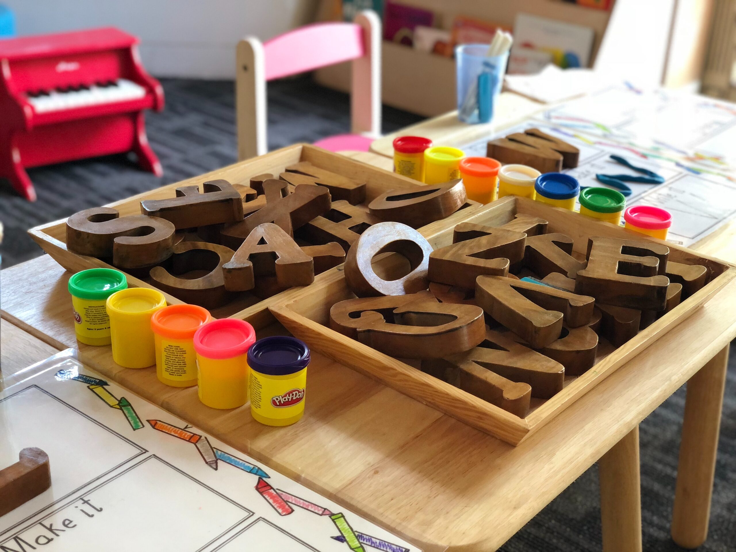 Picture of wooden block letters in a classroom with play dough surrounding