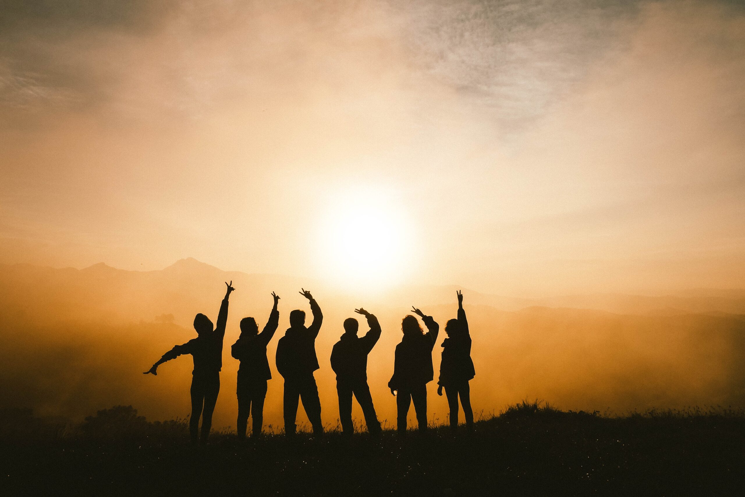 image of group of people posing in front of sunset