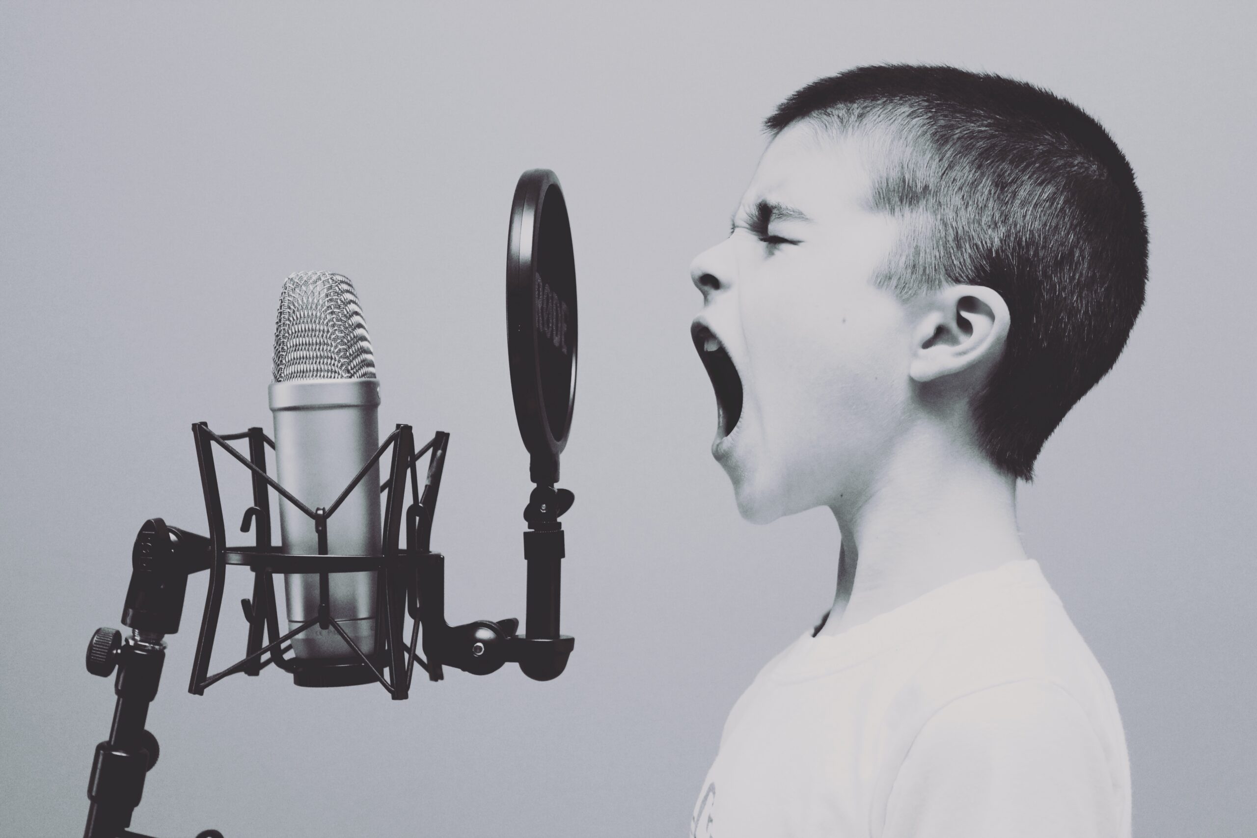 A little boy yelling into a microphone.