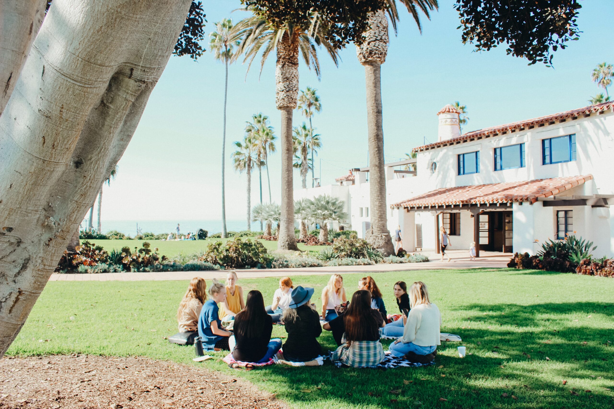 People sitting on ground forming round during daytime