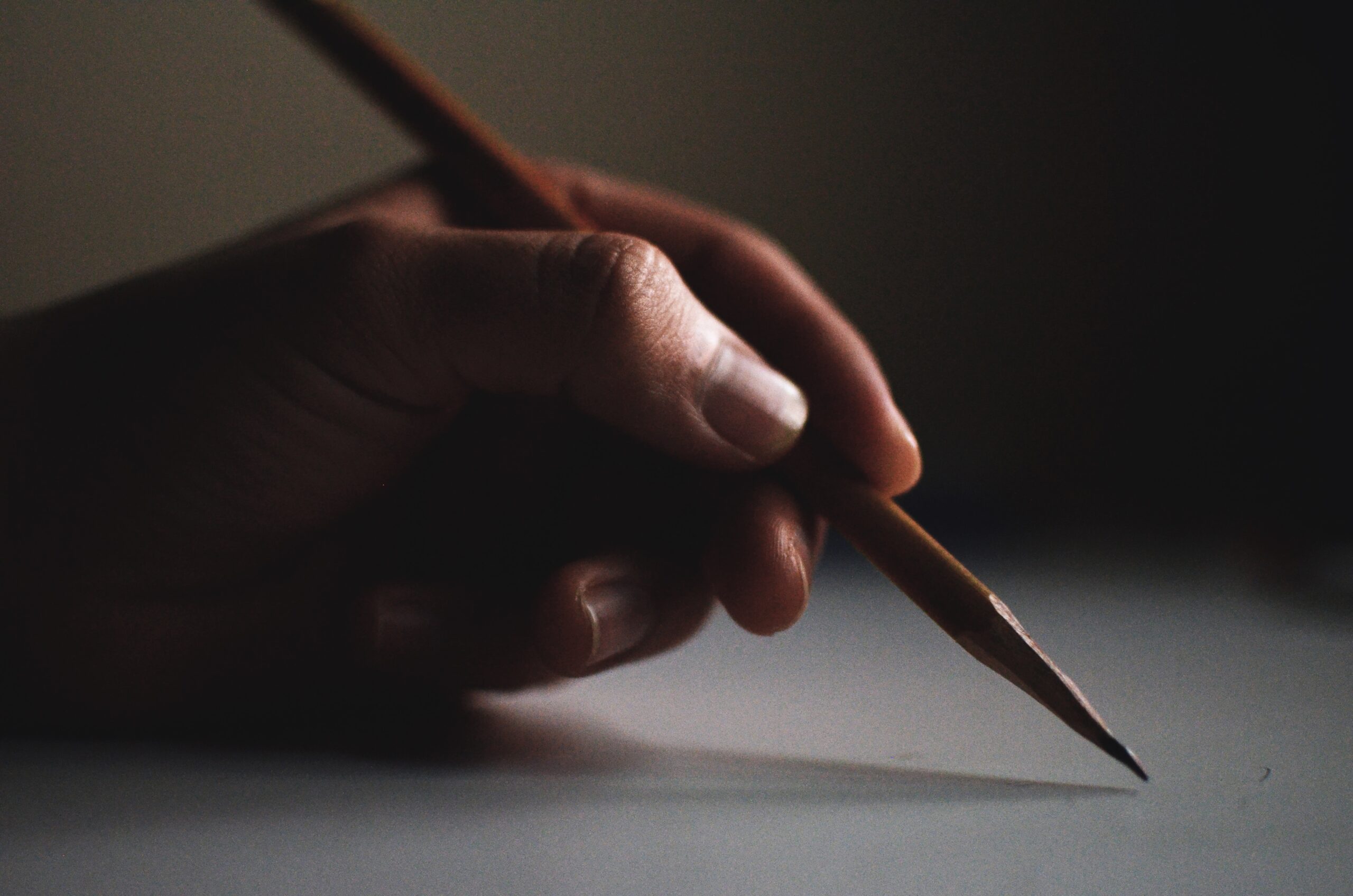 A person's hand writing on paper