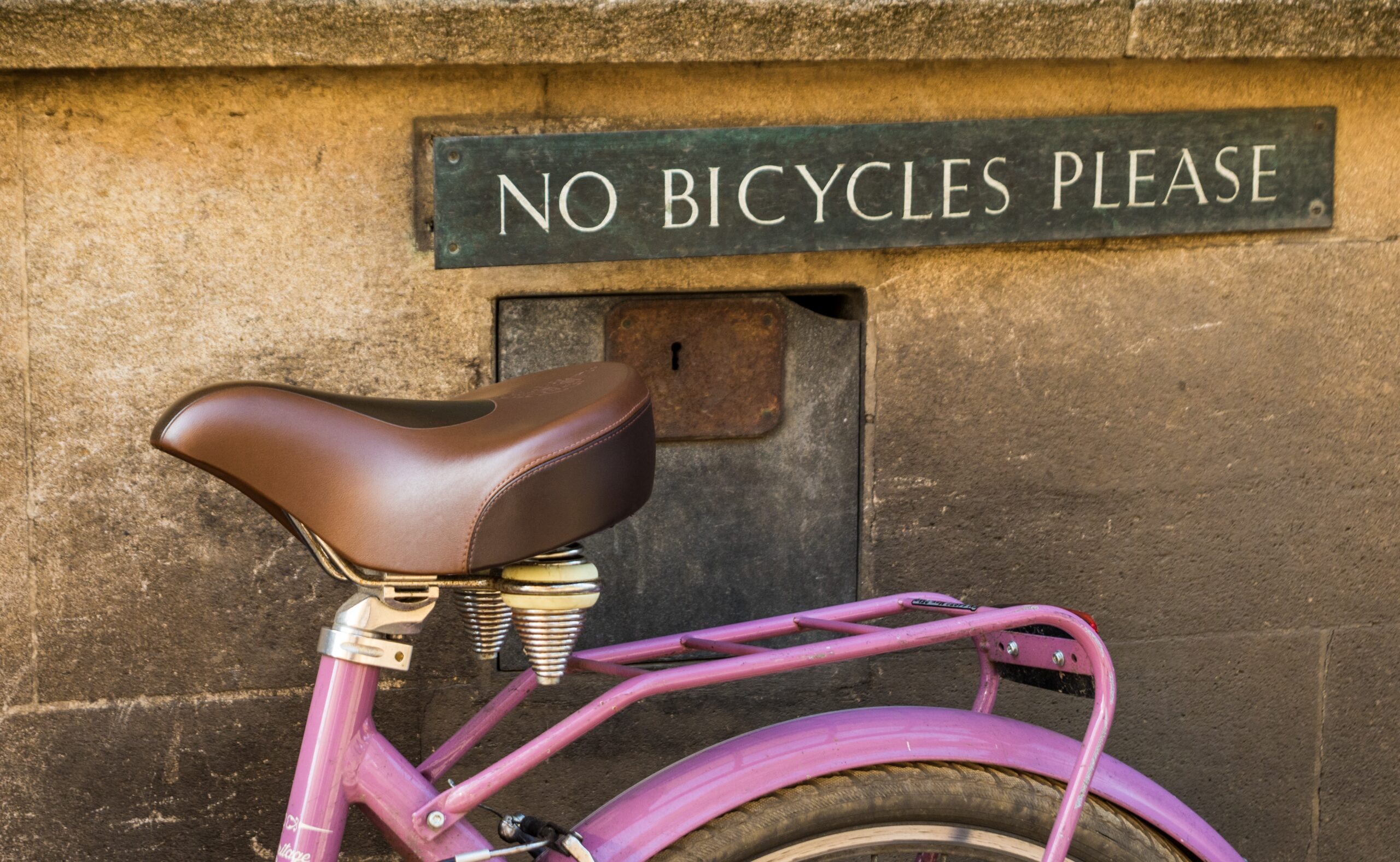 image of bike in front of a sign that reads "NO BICYCLES PLEASE"