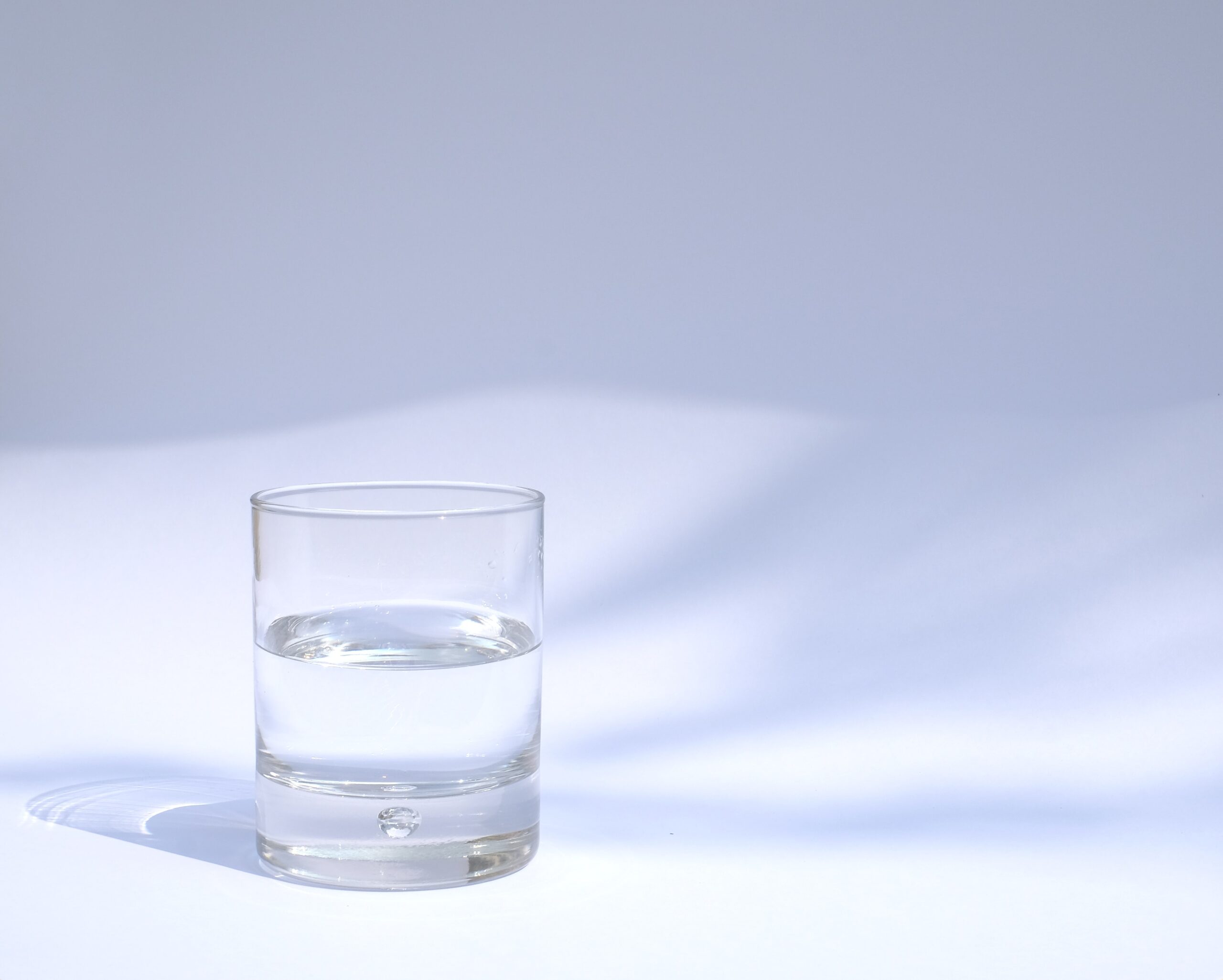 A glass of water against a white background. The glass is metaphorically speaking for optimism.