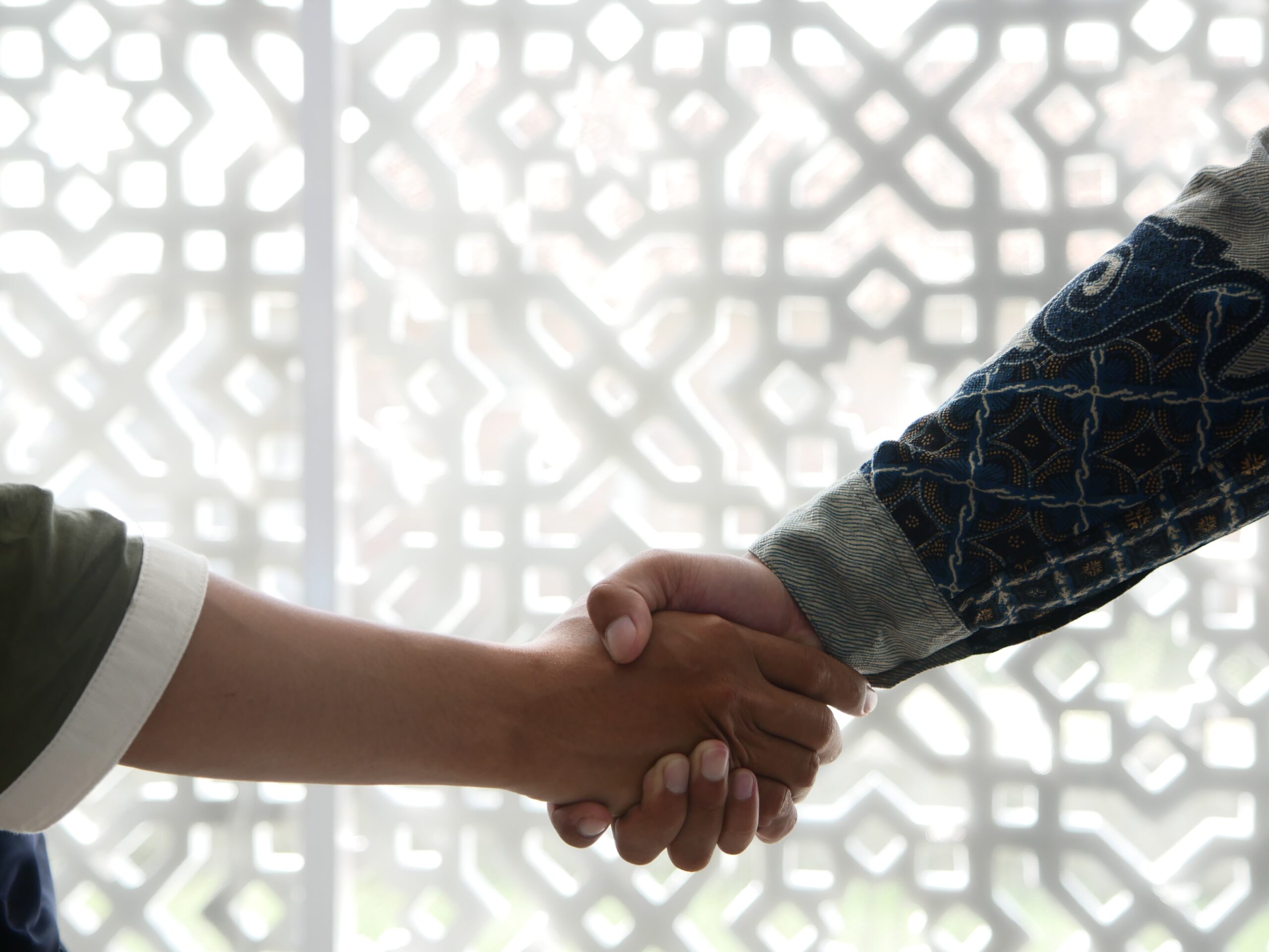 A photo of two people shaking hands. It is meant to signal that they are on the same page.