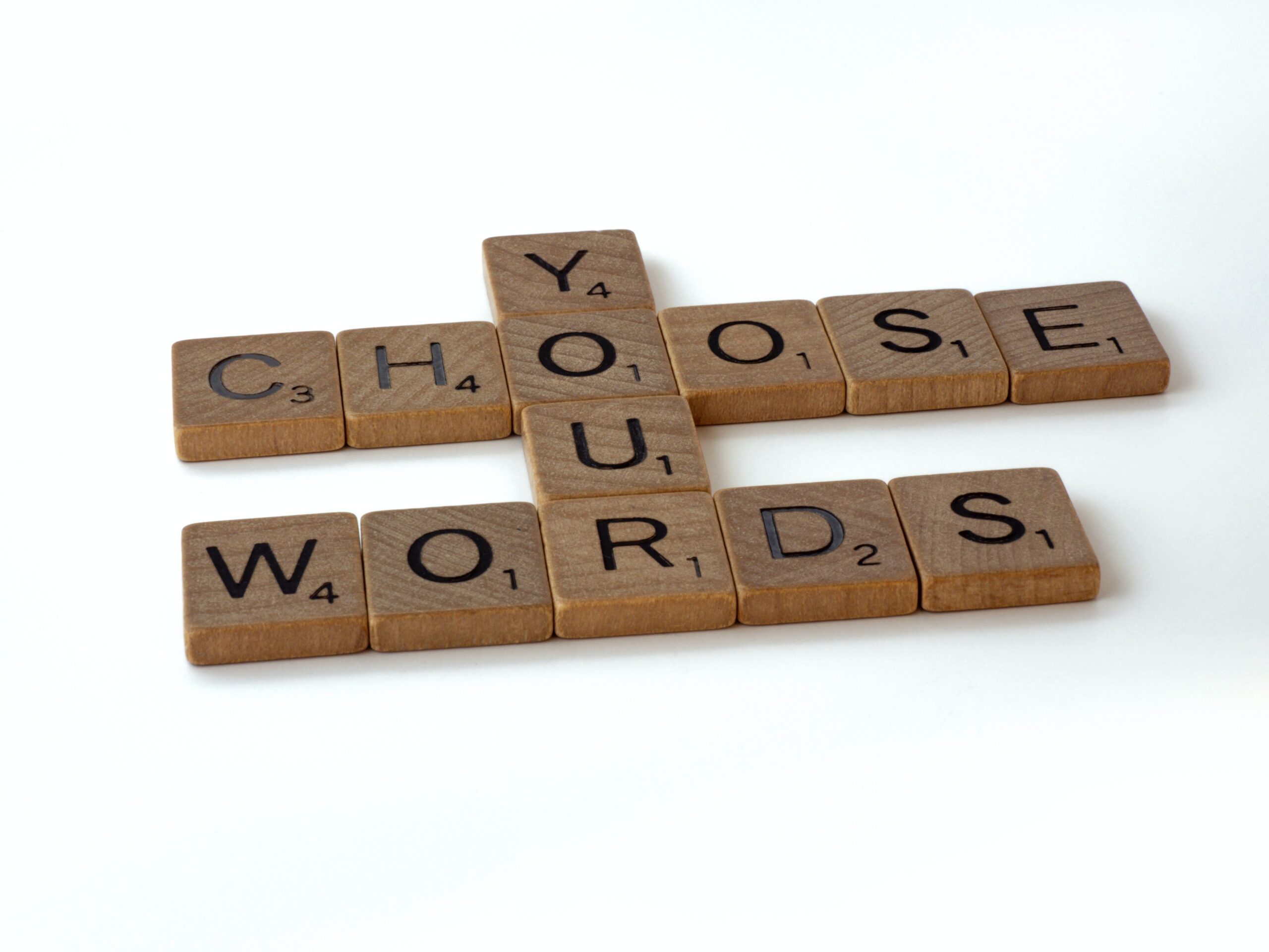 scrabble pieces that spell out Choose Your Words. It's an example of language and grammar