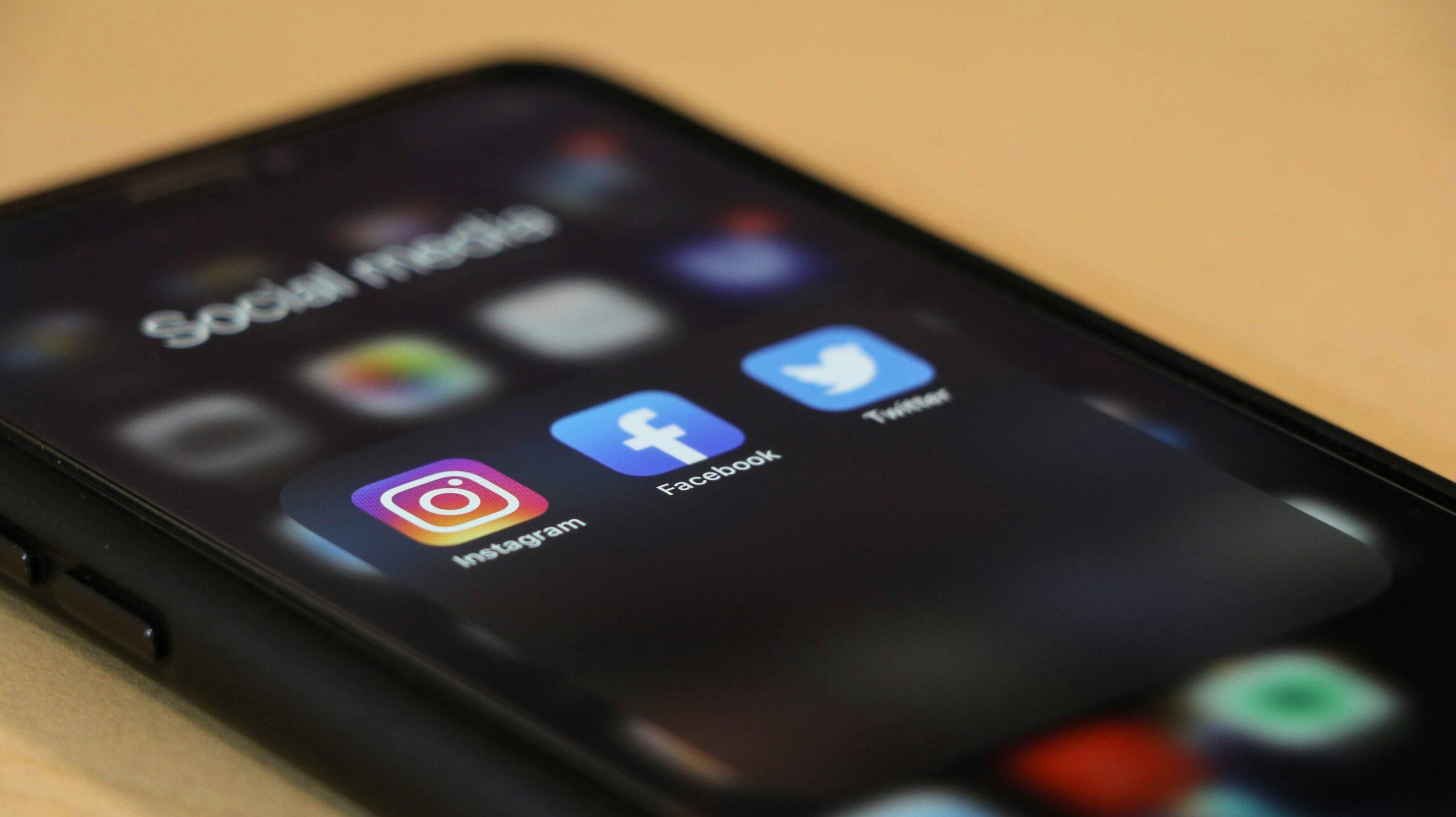 An iPhone opened with three available social media apps: Instagram, Facebook, and Twitter (X)