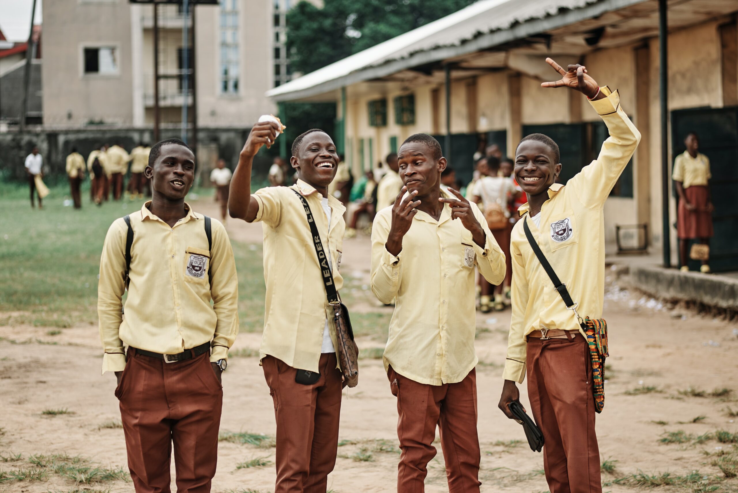 Four teenage kids in school uniform outside their school building