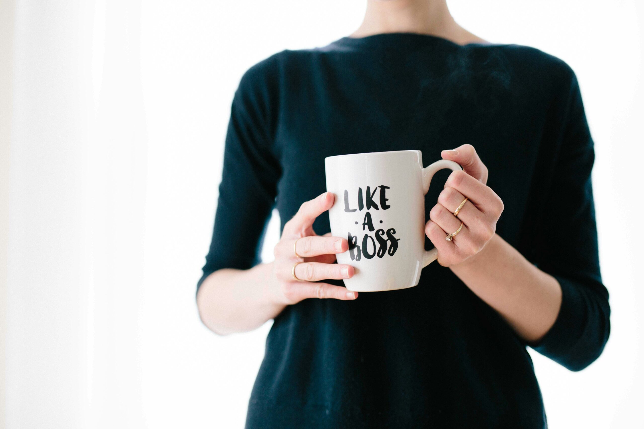 woman holding a mug that reads "like a boss"