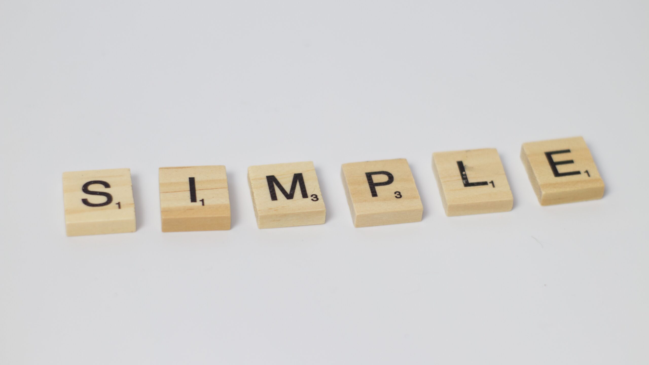 scrabble pieces spelling the word simple on a white background. This signifies ease and credibility.