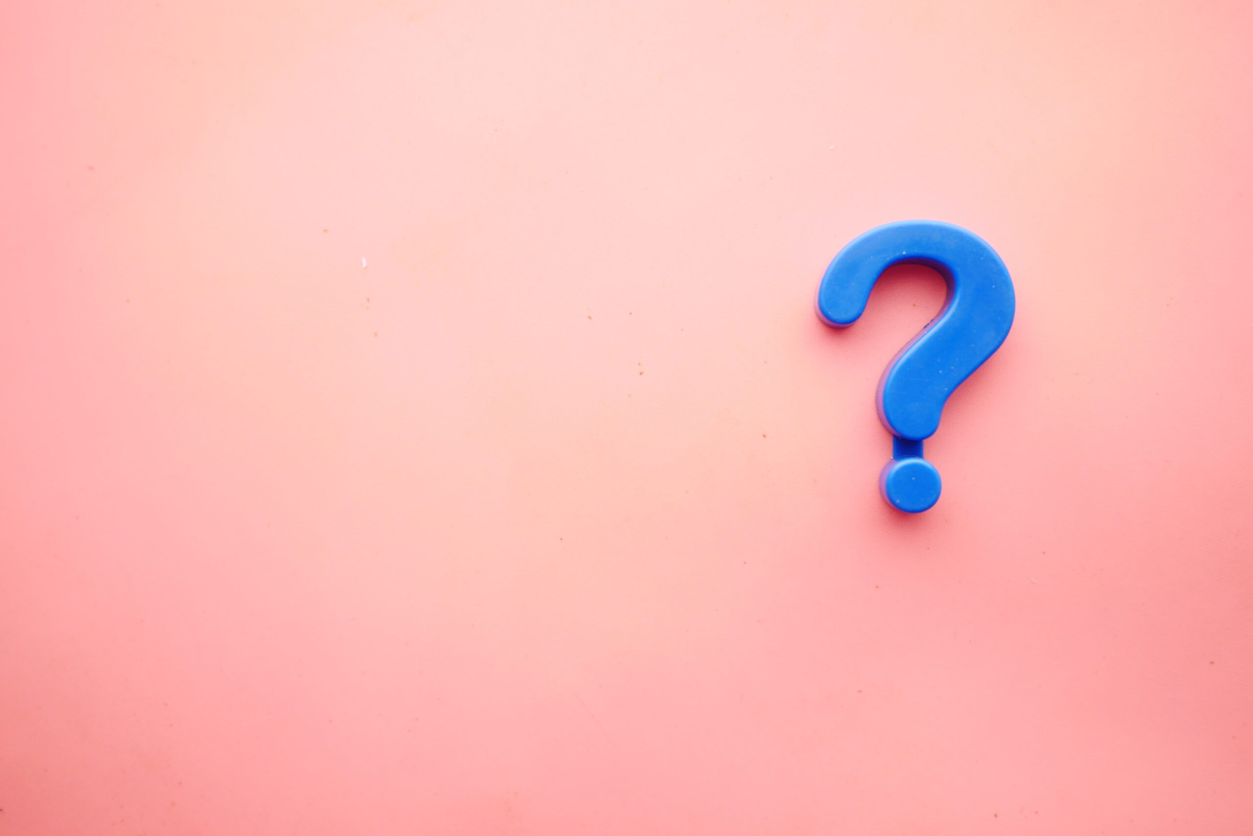 A blue question mark on a pink background