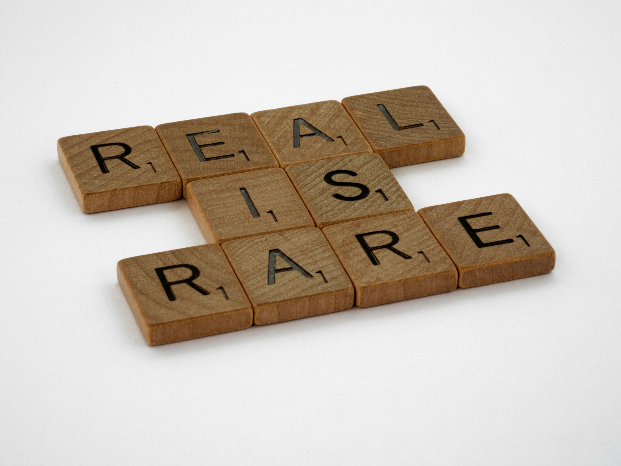 scrabble pieces spelling out "real is rare"