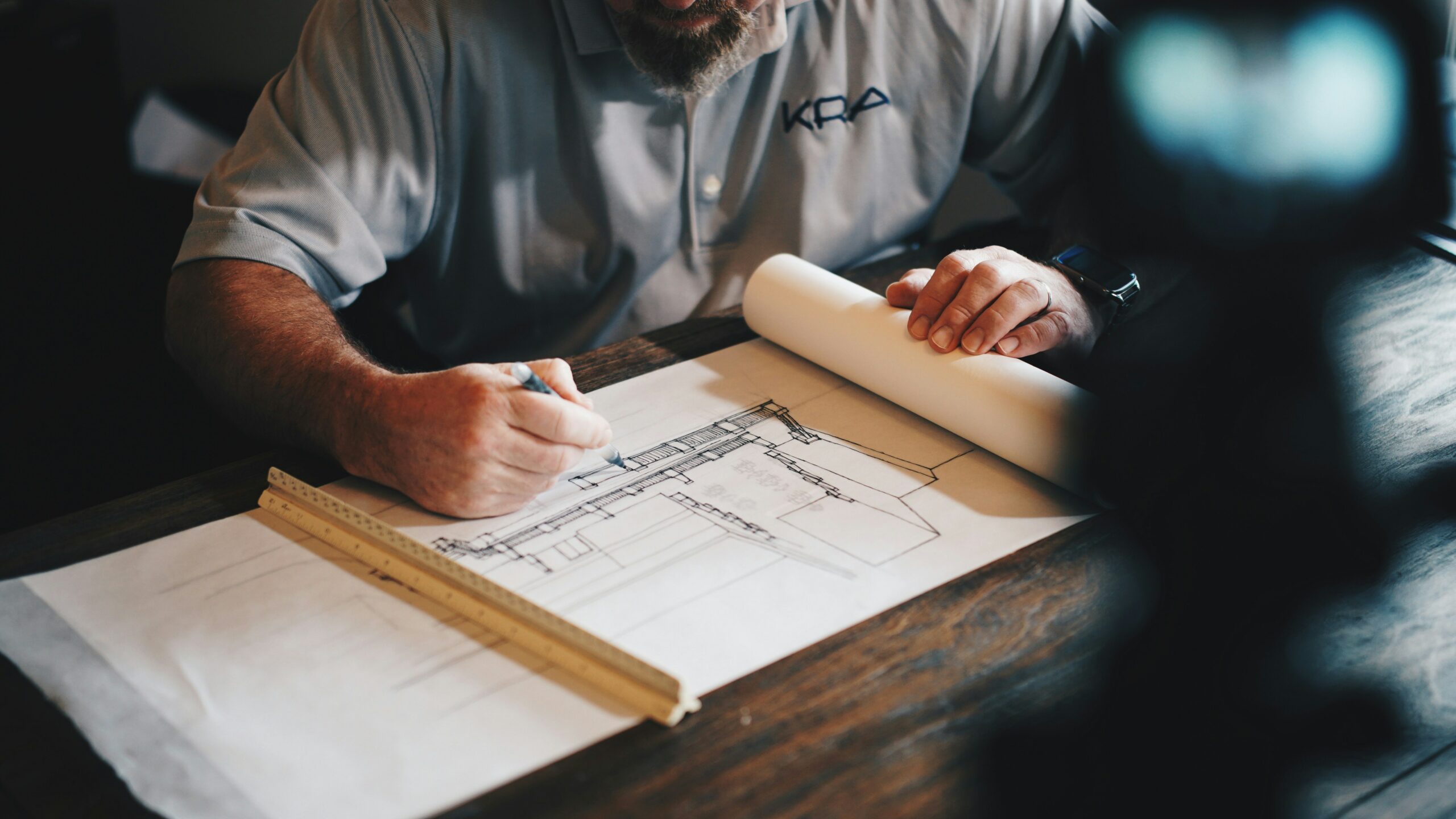 A man is sketching a design for a building.