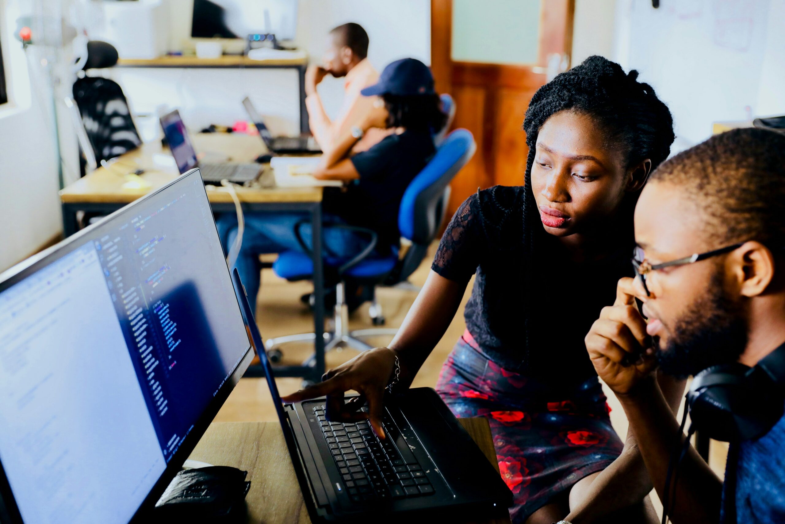 two people looking at screen, one teaching other