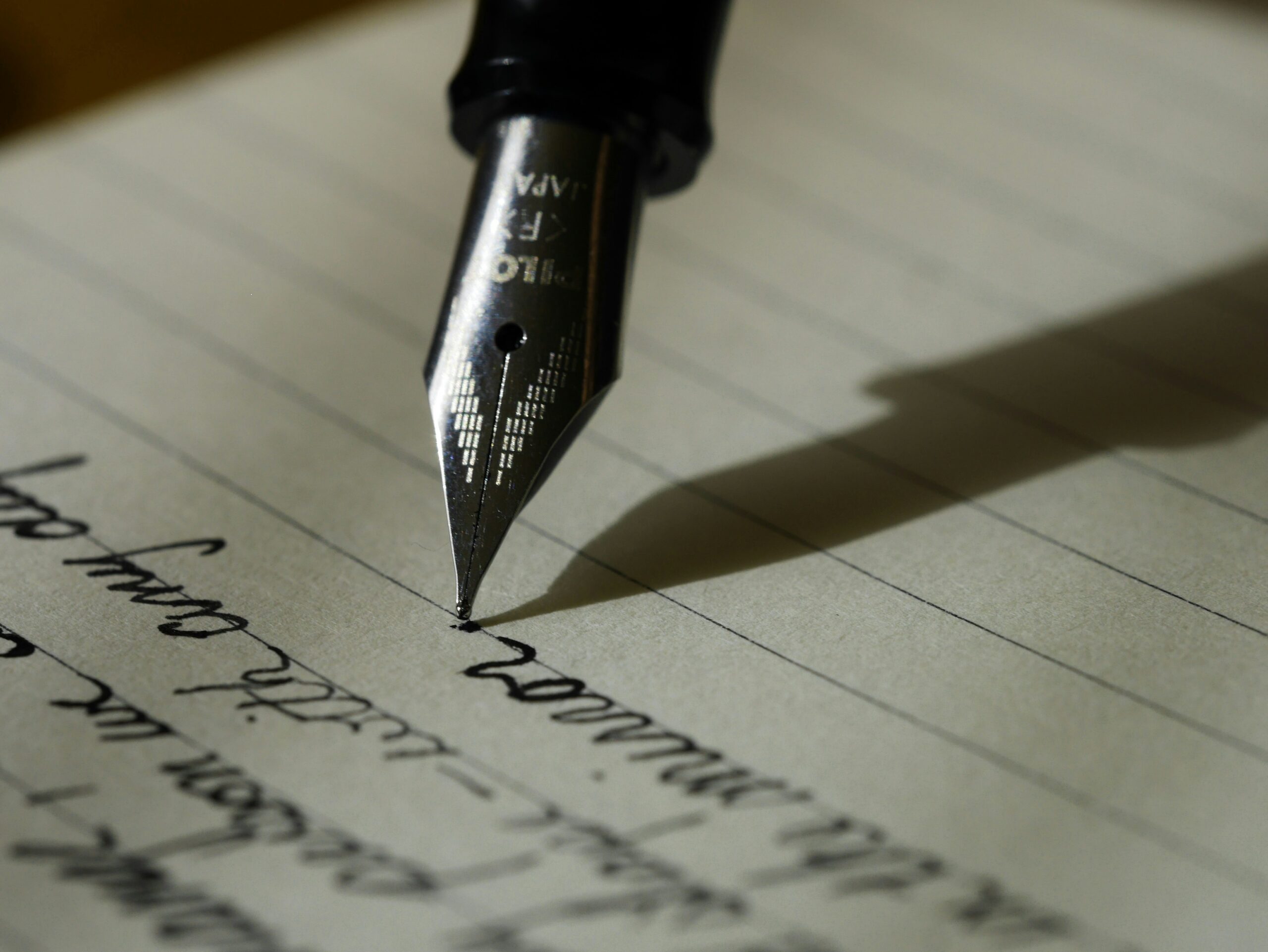 A pen writing on a sheet of loose leaf paper