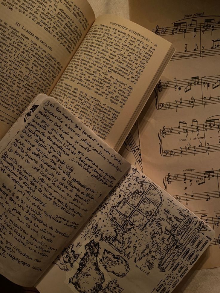 an open journal laying on an open book that is laying on a music sheet