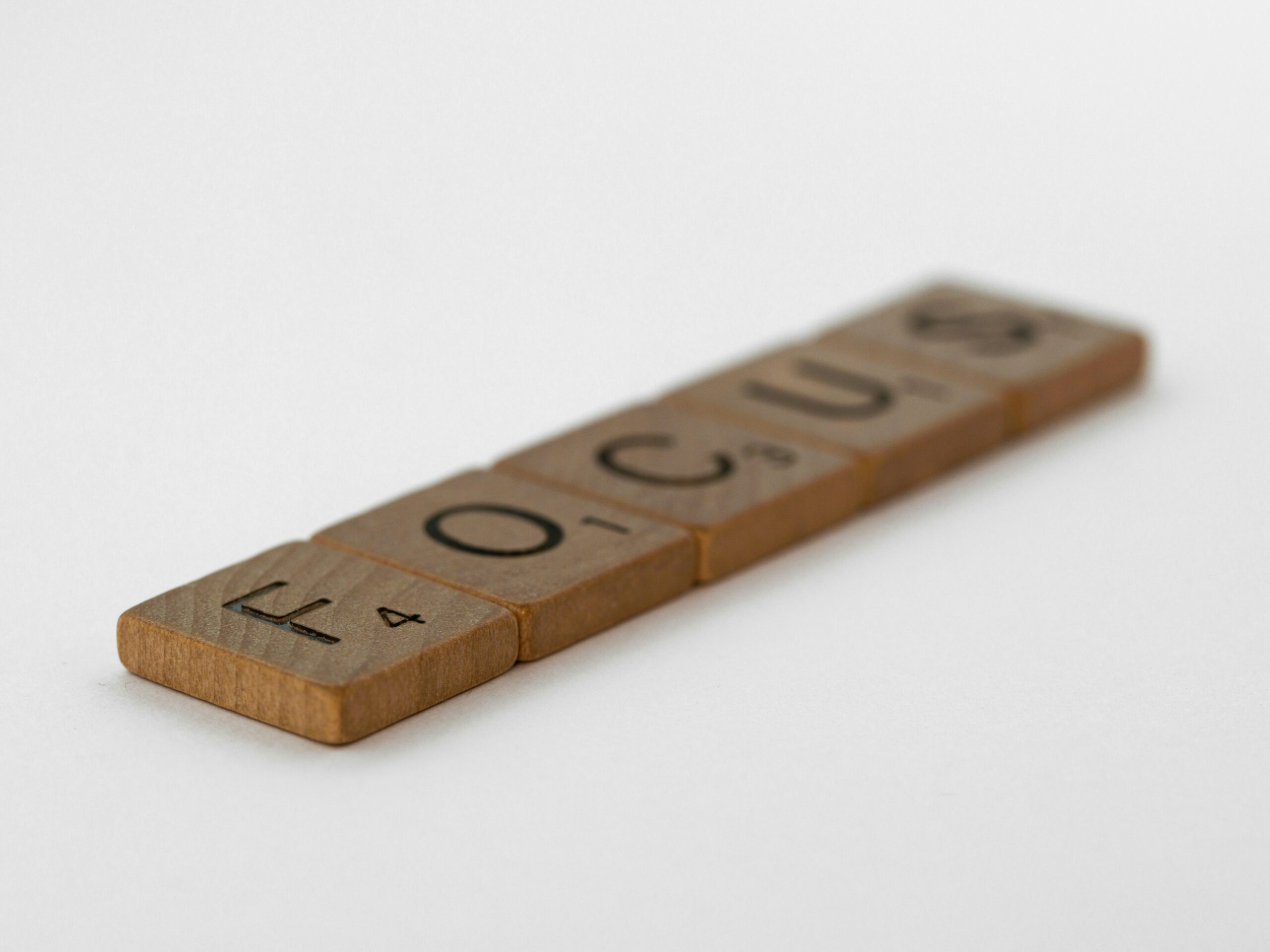 Five scrabble pieces are aligned to form the word "Focus."