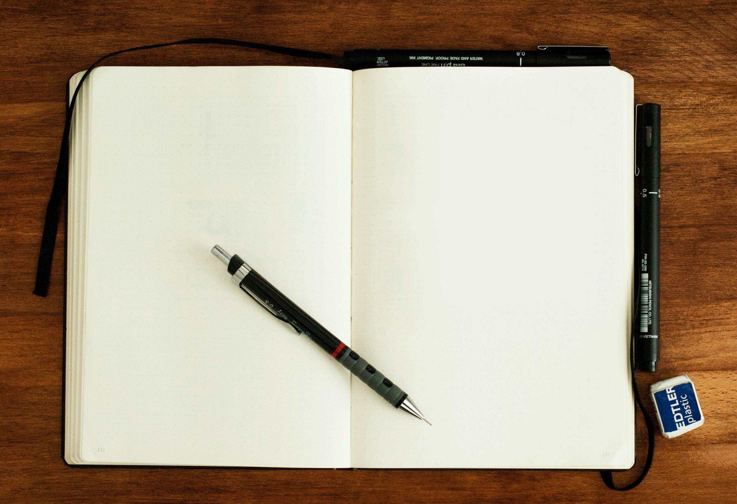 Photo of a blank notebook with a pen on top.