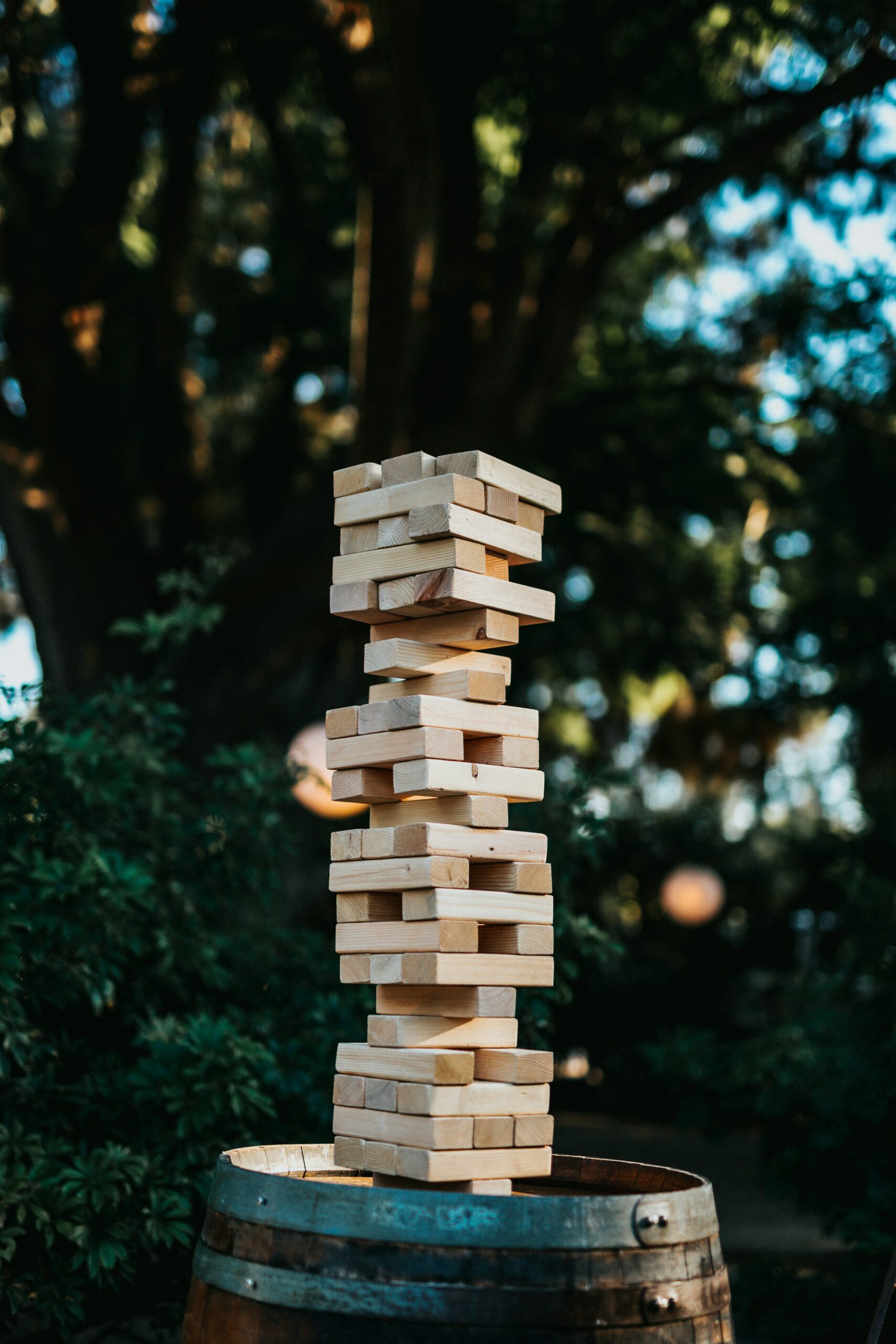 Jenga pieces have been built into a tower. Some pieces from the middle are missing and placed on the top.