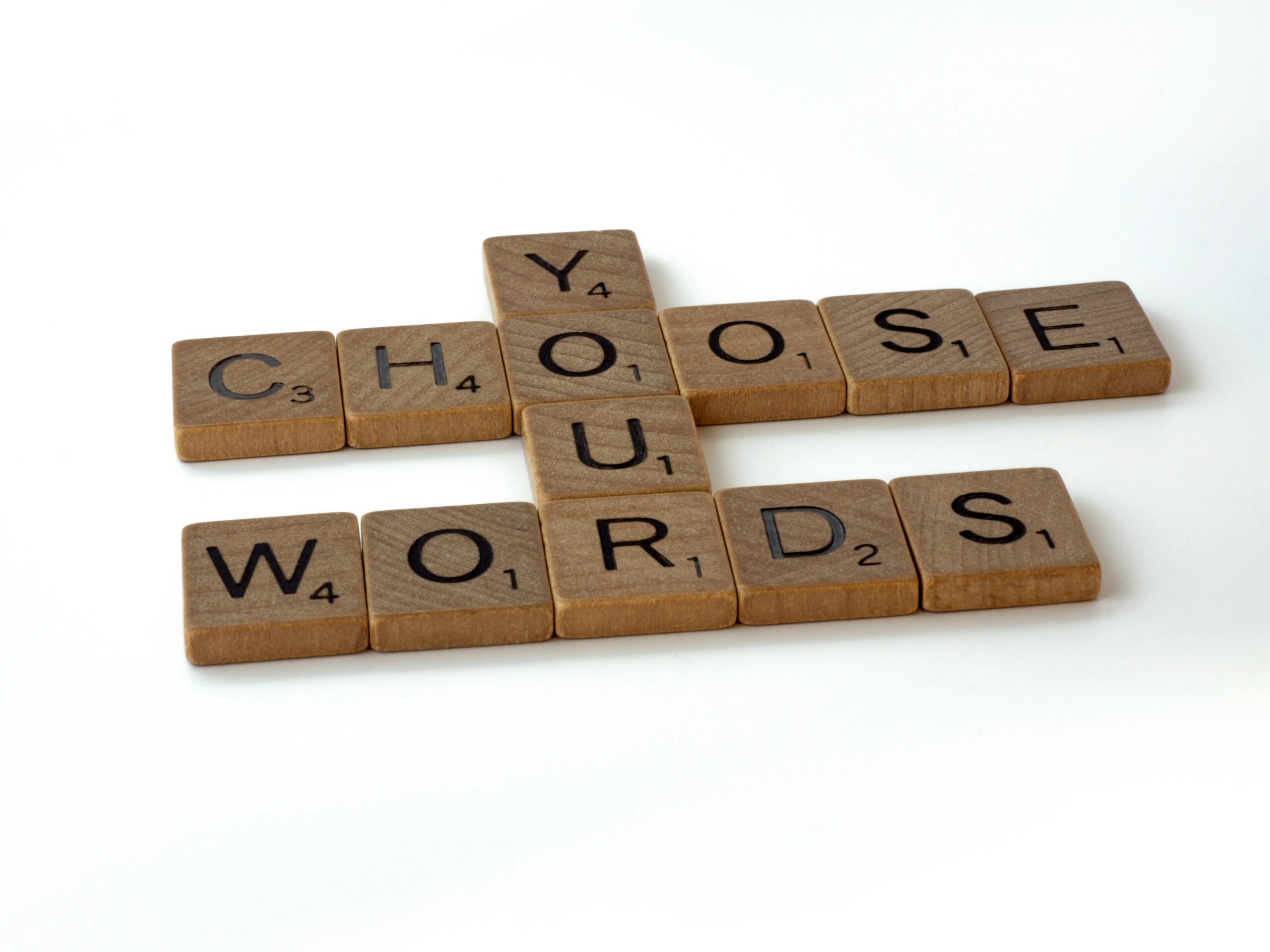 Letter blocks that spells out choose your words. Choose and words are going across, while your is going down through them.