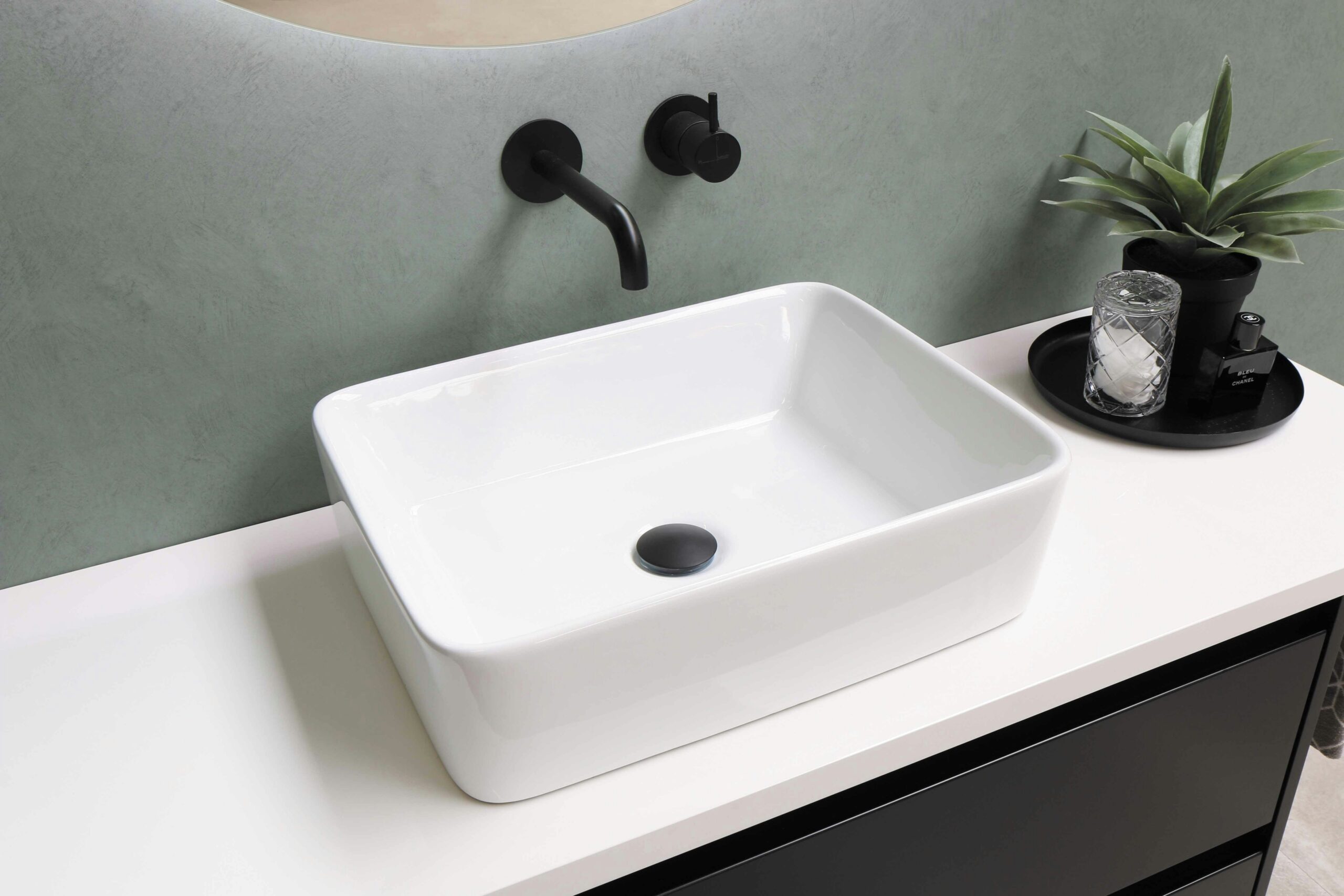 A sink that looks like a square bowl atop a counter. The faucet is bent, like a sippy straw, and coming out of wall.