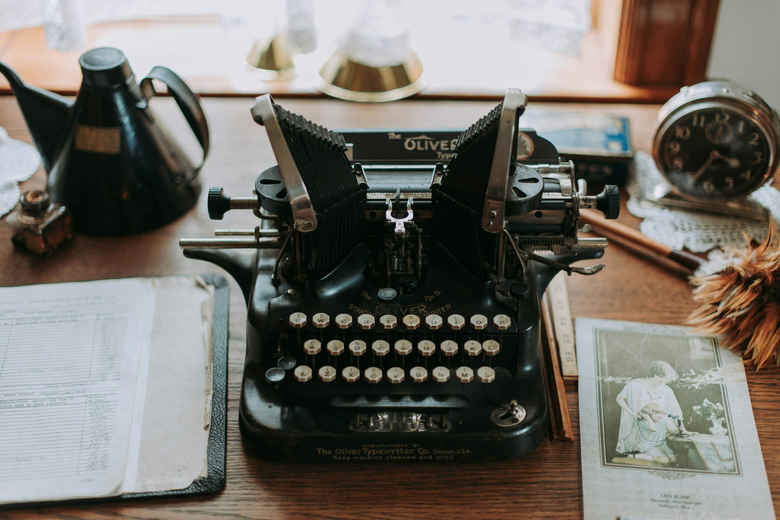 Wooden desk with a vintage black typewriter on the center of it.